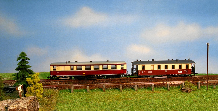 ein Wanderer gr&uuml;&szlig;t den Schmalspurtriebwagen mit seinem Anh&auml;nger